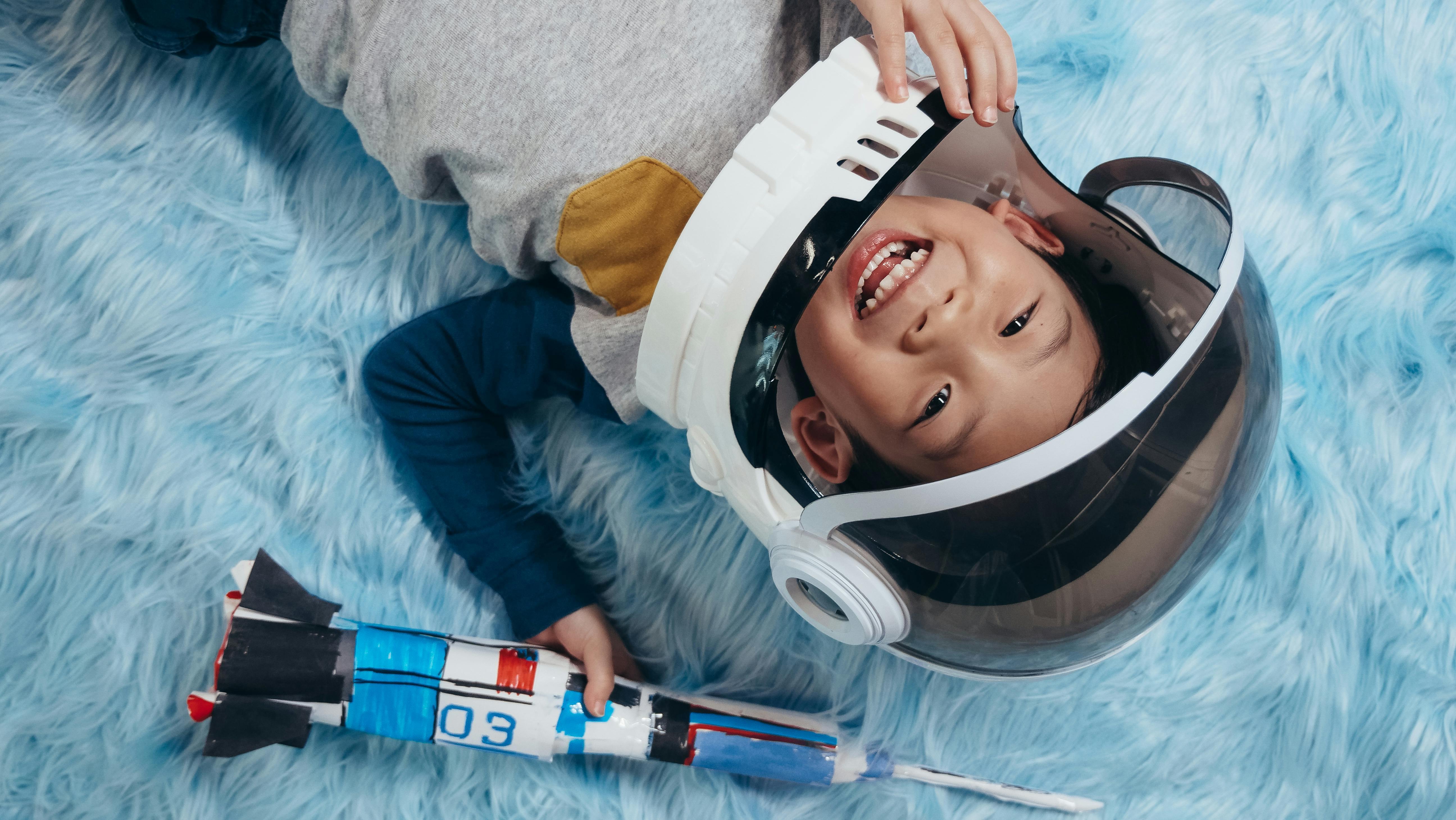 Child wearing astronaut helmet, dreaming of space adventures